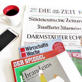 Zeitungen, Kaffeetasse und Handy