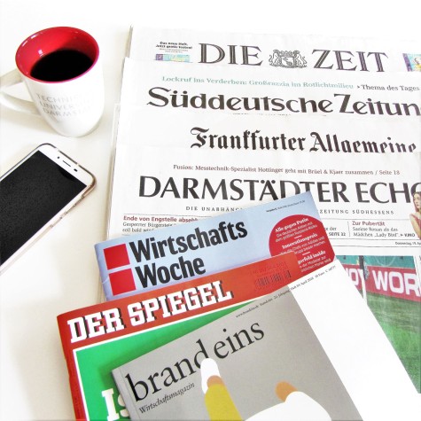 Zeitungen, Kaffeetasse und Handy