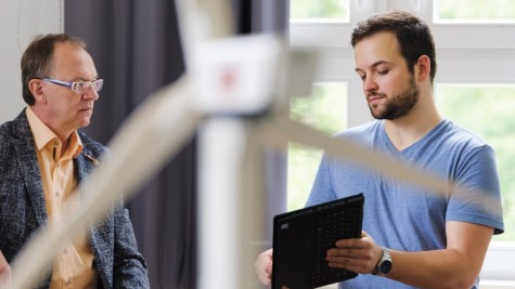 Im Hintergrund unterhalten sich Prof. Max Mühlhäuser und Doktorand Rolf Egert. Im Vordergrund ein unscharfes Windrad.