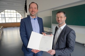 Dekan Chtistian Reuter übergibt dem neuen Privatfozent Andrea Tundis seine Ernennungsurkunde.