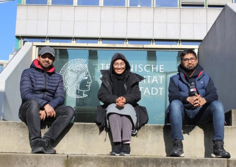 Die Gründeri*innen von PrescripAI Riazuddin Kawsar, Sayeda Samia Nasrin, Mokammel Antik Khan (von links nach rechts) vor dem Karo 5 mit Logo der TU Darmstadt. Mitgründerin Umme Jobira Ahmad ist nicht im Bild.