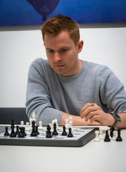 Johannes Czech sitzt vor einem Schachbrett und plant den nächsten Zug.