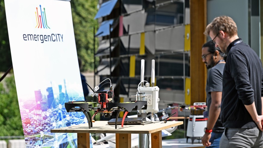 Zwei Personen stehen an einem Stand mit Demonstrator von emergencity.