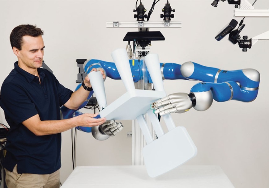 Jan Peters bedient Roboterarme, die Kinderstuhl halten