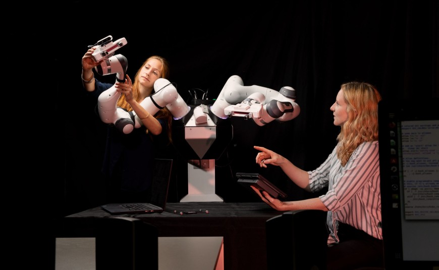 Zwei Forscherinnen bedienen einen Roboterarm